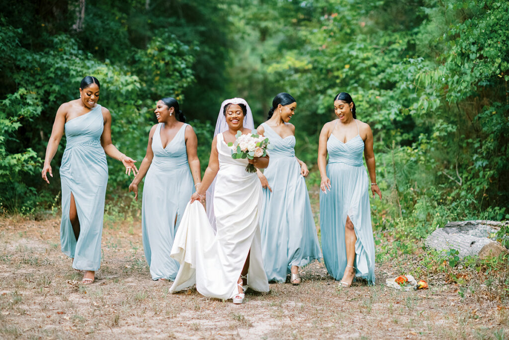 Black Bridesmaids walking in woods wearing Green Dresses at the Shire in Huntsville